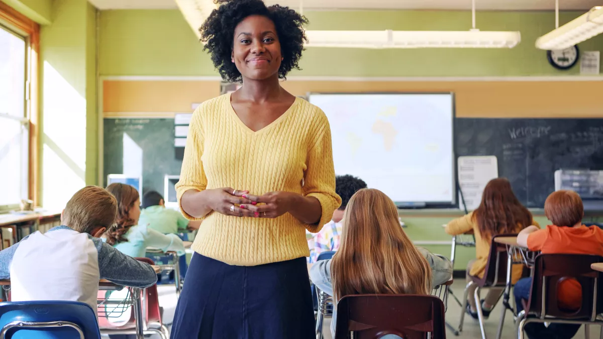 Teacher stands proudly in front of her students.