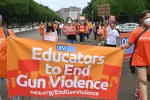 Educators march with a banner that says "Educators to end gun violence"