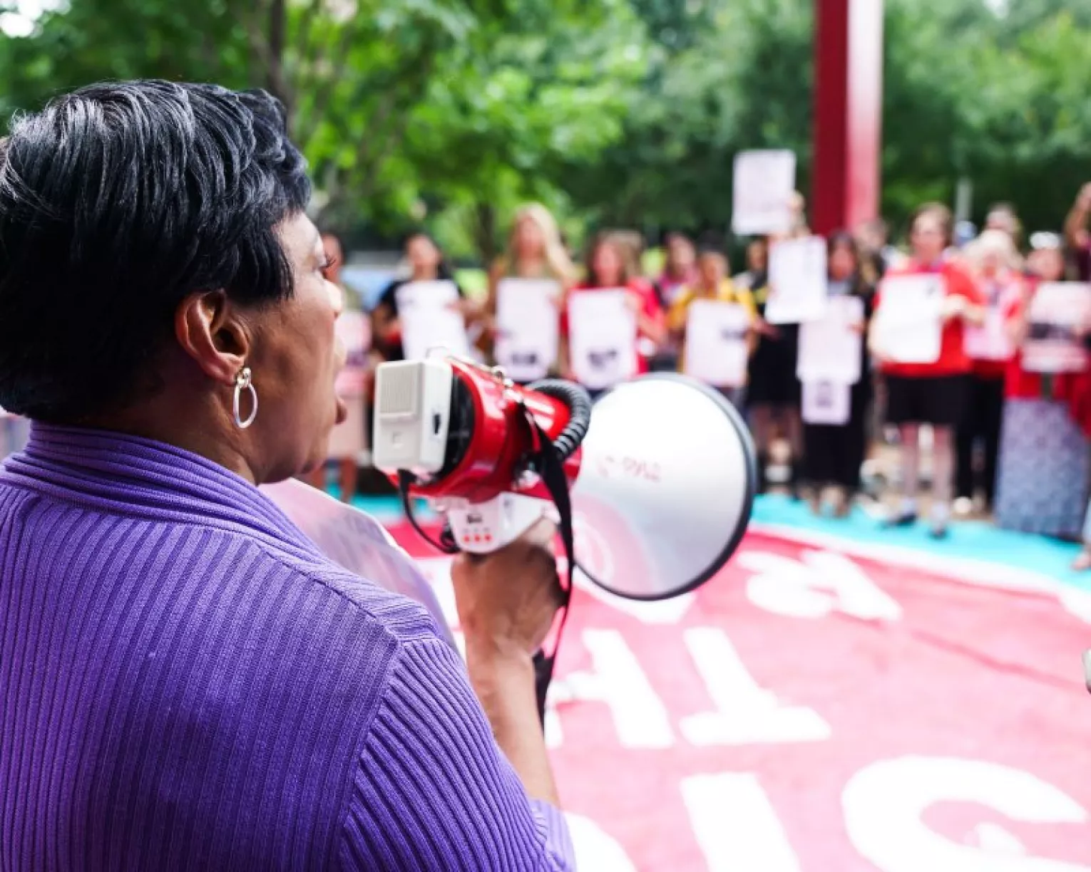 NEA President Becky Pringle stands with a bullhorn at a rally to support students.