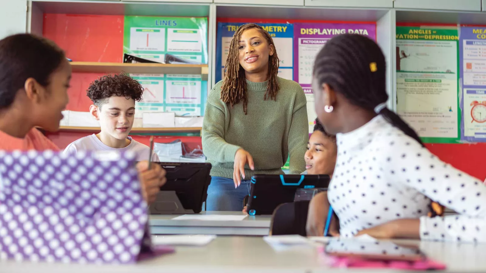 Female teacher of color having a discussion with students