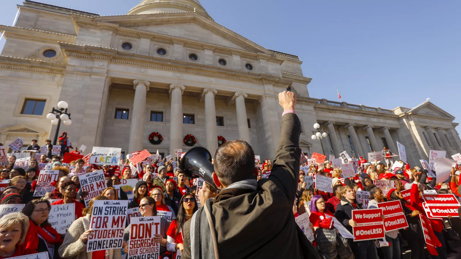 Man w/fist raised in front of a protest at the Arkansas capitol