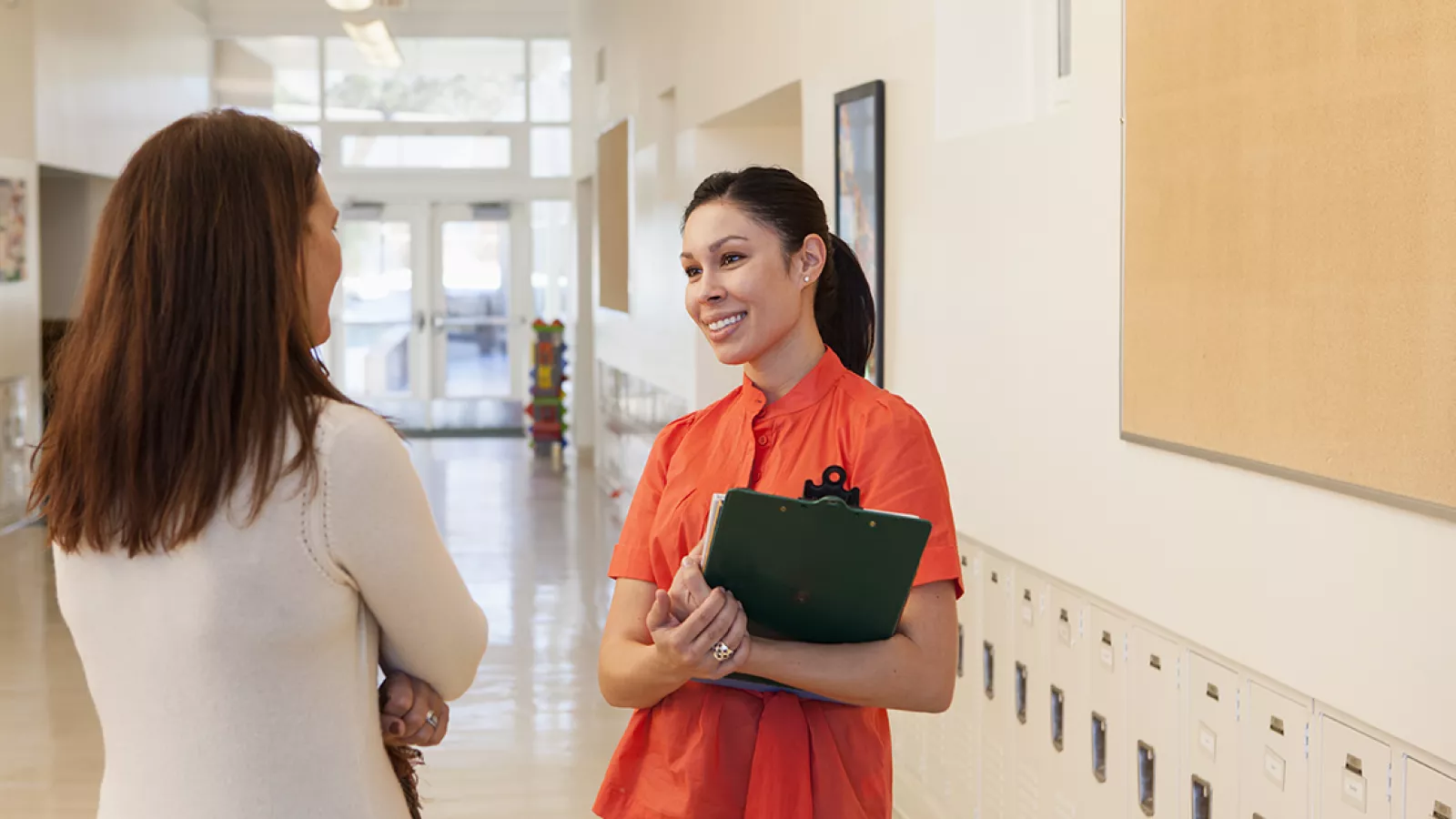 image of two educators talking in a school hallway