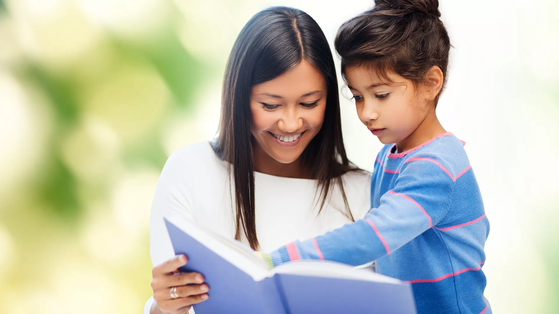 Mom and daughter reading a book together