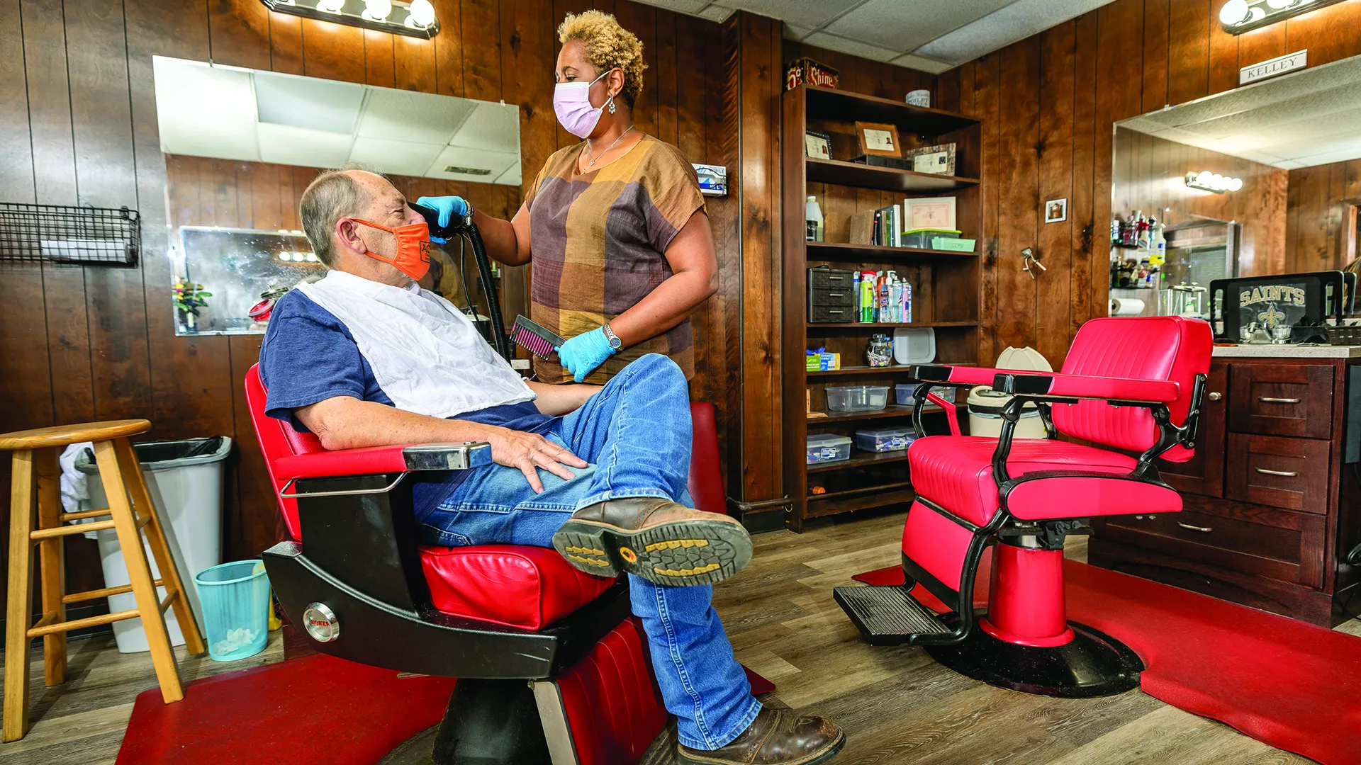 Retired teacher Sherri Kelley Barber with a customer in her barbershop