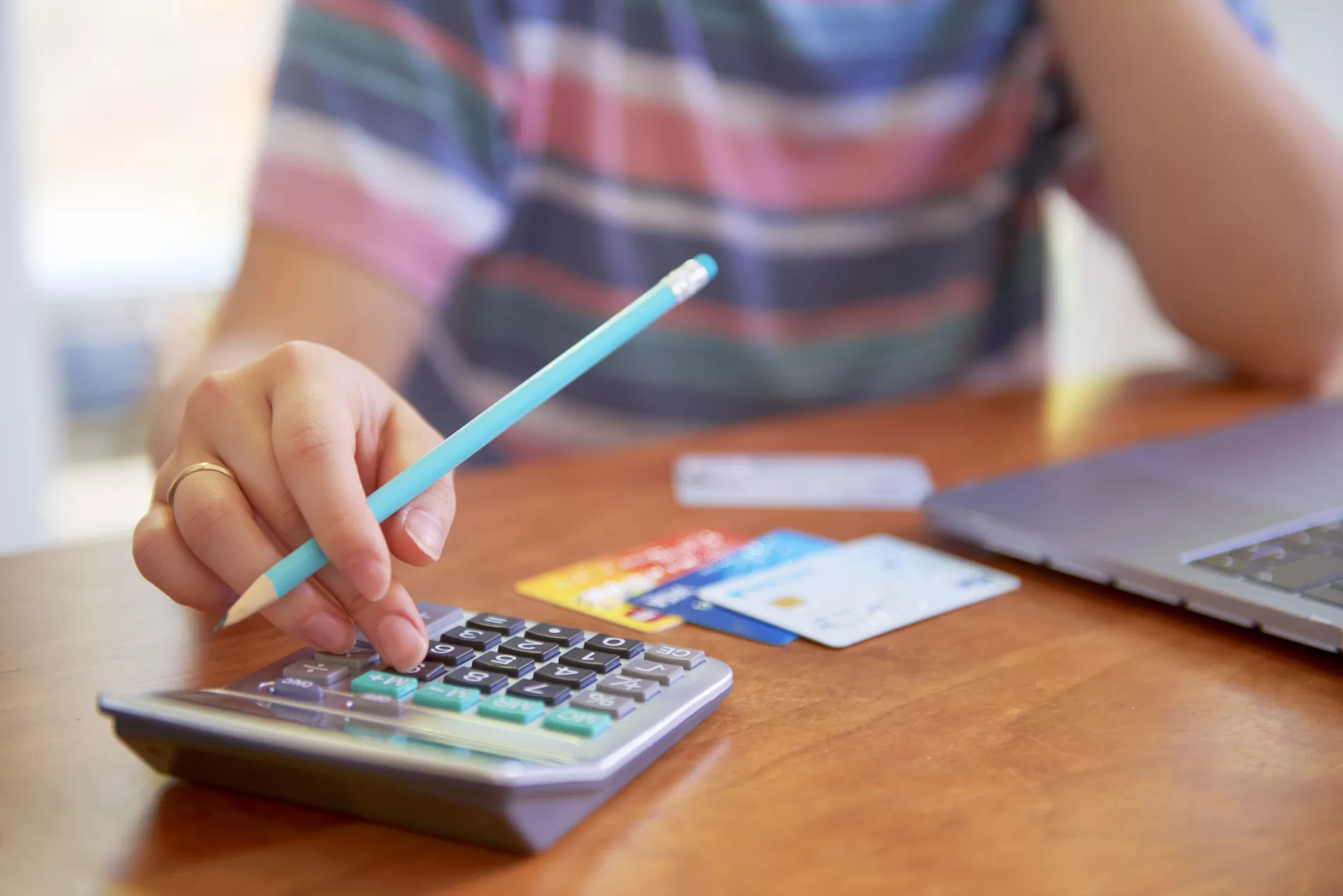 Person with a calculator and credit cards deals with financial issues.