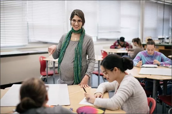 Pregnant teacher interacting with students