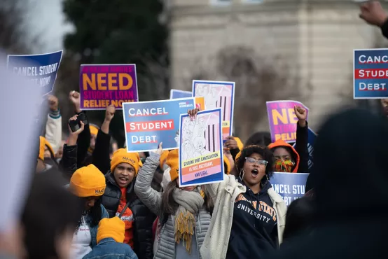 Photo of young people, many of them Black, cheering for debt cancellation