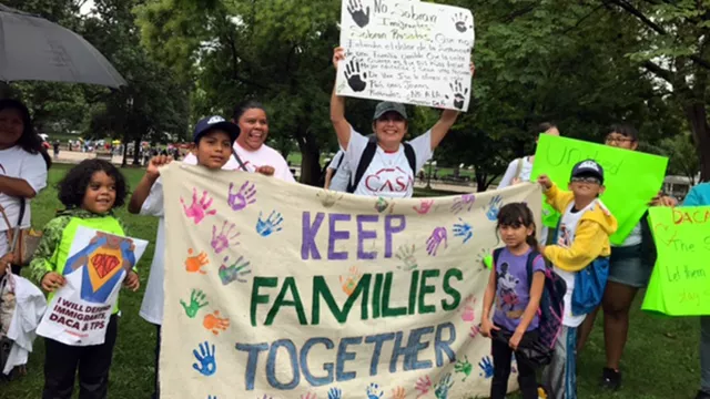 activists protesting immigration policy holding a sign that says Keep Families Together