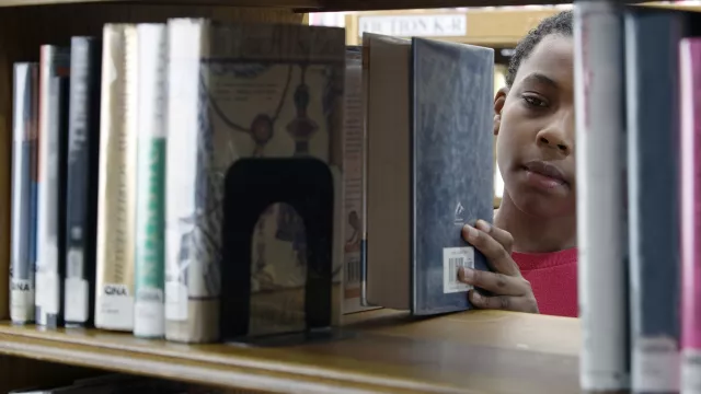 young boy in library stacks
