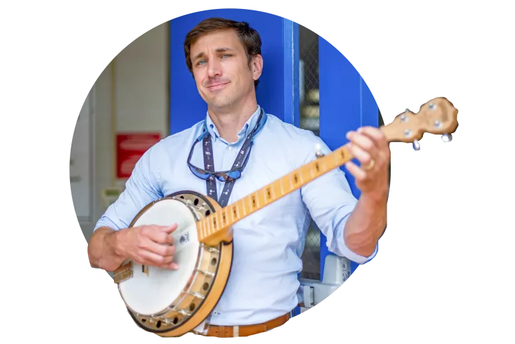 Teacher Pete Stone poses with a banjo
